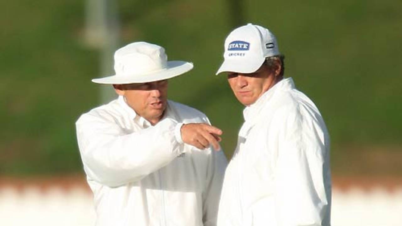 The umpires Barry Frost and Phil Jones are concerned about the light