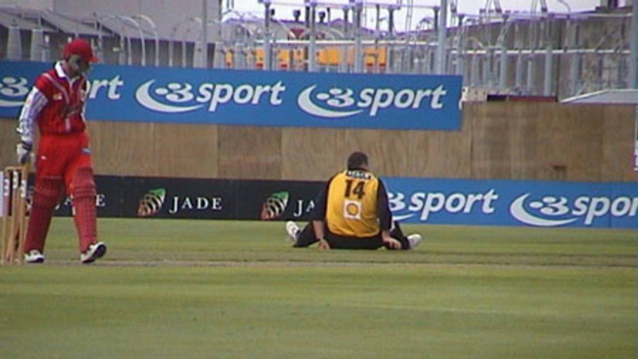 Wellington bowler Matthew Walker stretches in between overs while Canterbury batsman Gary Stead looks on, Shell Cup: Canterbury v Wellington at Jade Stadium, Christchurch, 18 January 2001