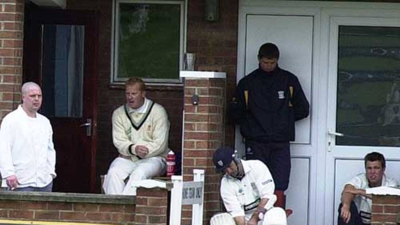 Injured Durham batter Jimmy Daley waits to resume his innings with coach Moxon behind and Nicky Peng watching anxiously