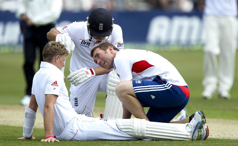 Joe Root receives some treatment after being hit on the knee ...