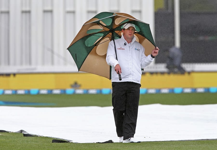 Shaun Haig, the reserve umpire, inspects the covers