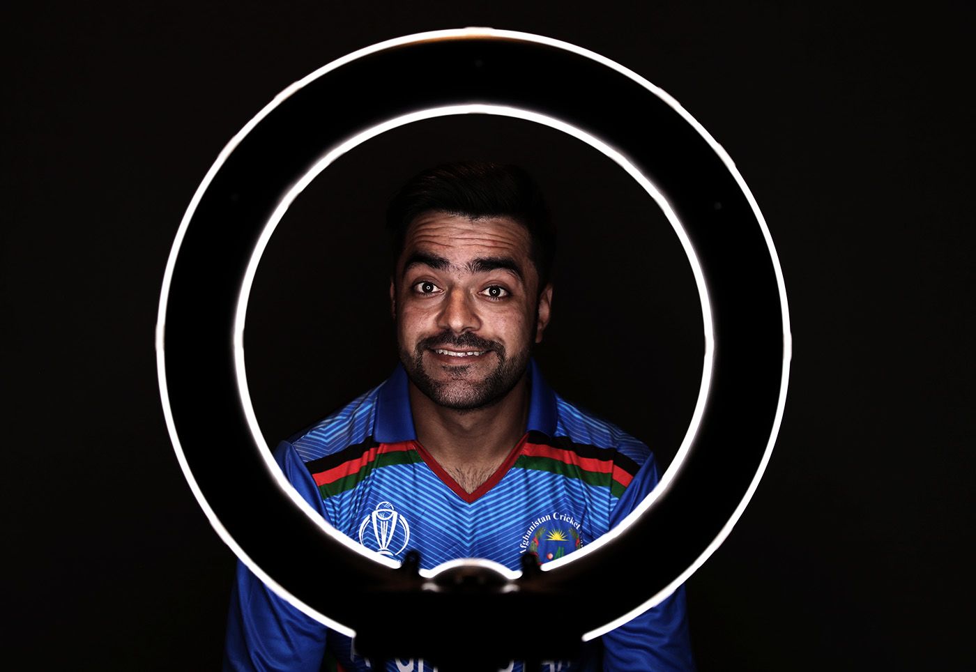 Rashid Khan looks at the camera through a ring light