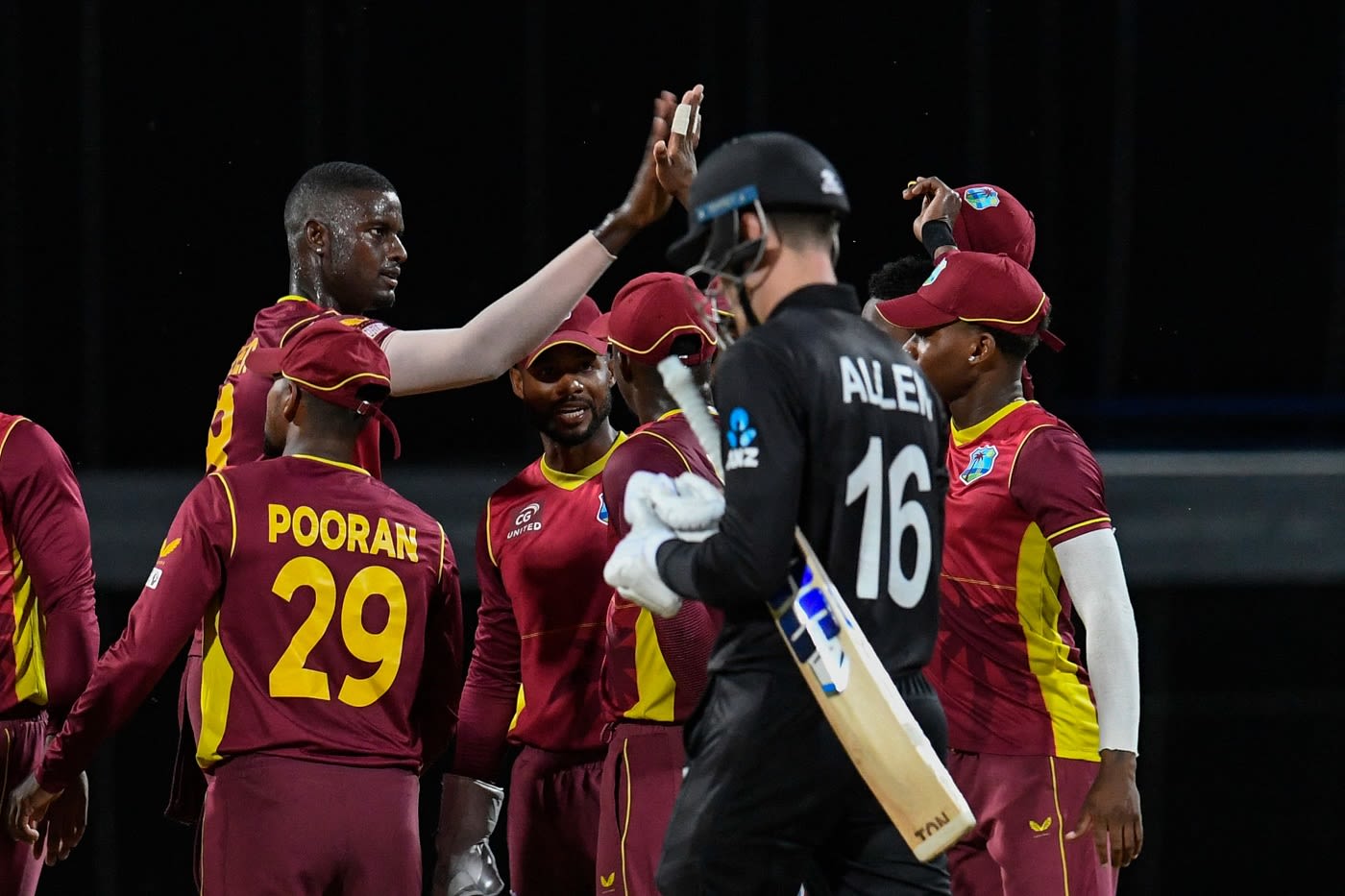 Jason Holder celebrates as Finn Allen walks back