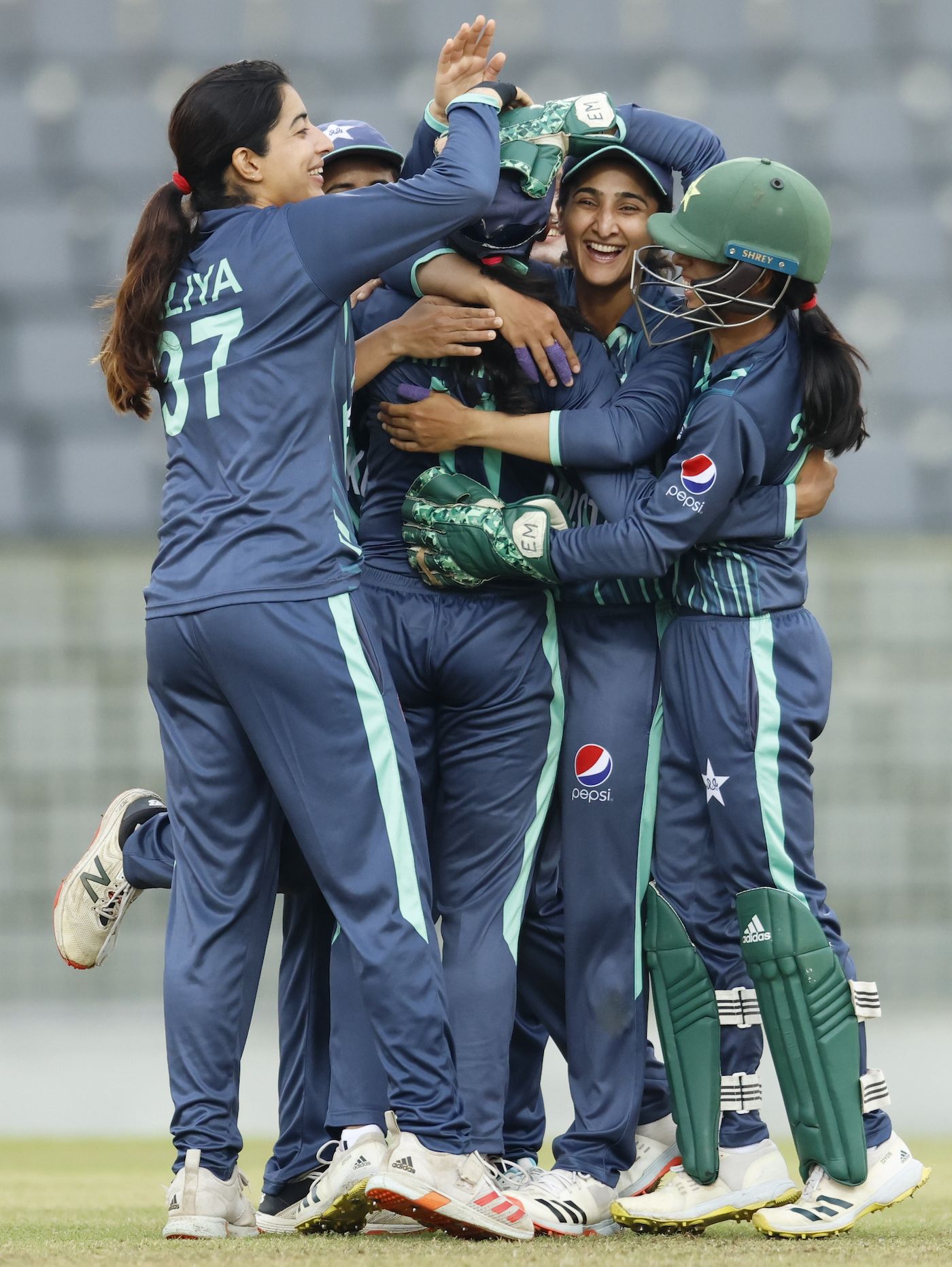 Omaima Sohail is mobbed by her team-mates after completing her five-for 