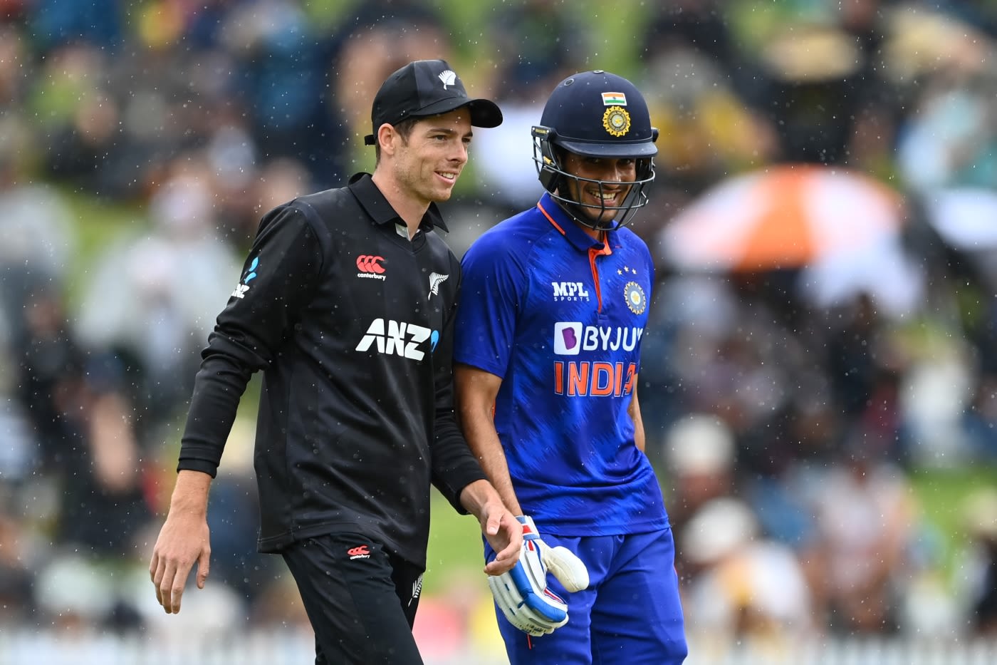 Mitchell Santner and Shubman Gill share a laugh in the drizzle ESPNcricinfo
