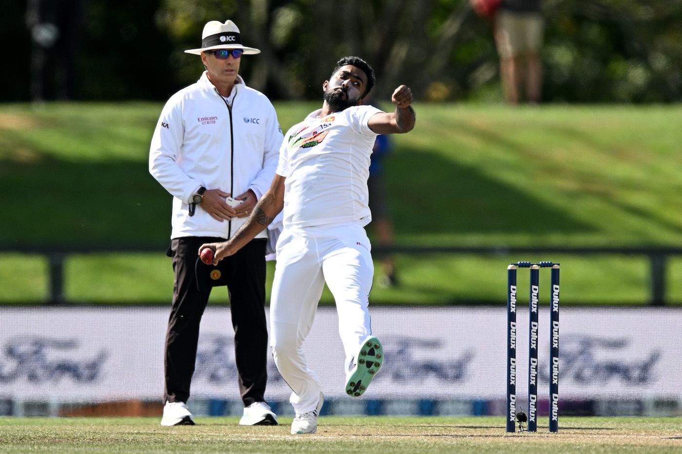 Asitha Fernando Bowls With Umpire Chris Gaffaney Standing Behind ...