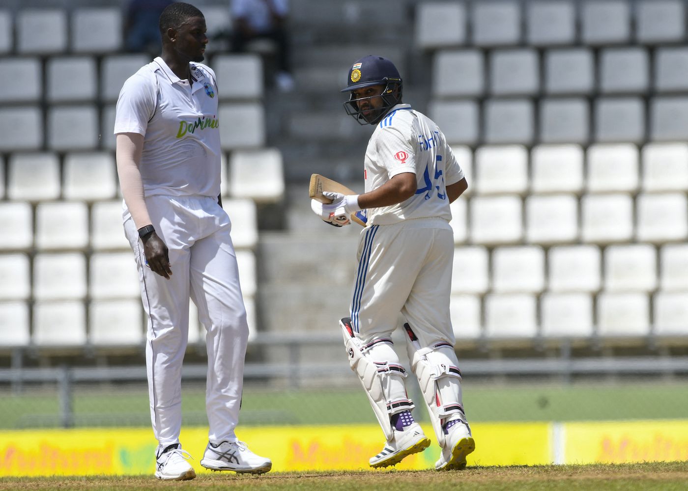 Rohit Sharma runs beside Jason Holder
