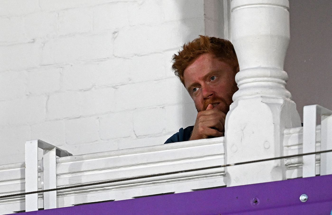 England's Jonny Bairstow watches from the pavilion after feeling