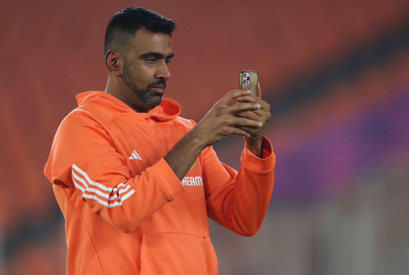 R Ashwin uses his mobile phone on the eve of the World Cup final