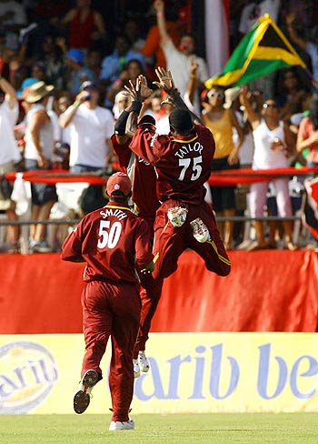 West Indies players celebrate the fall of Virender Sehwag