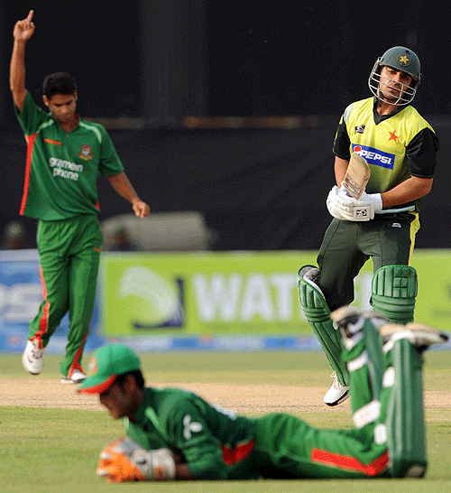 Salman Butt watches on as Dhiman Ghosh snaffles the outside edge ...