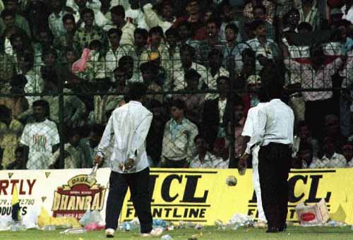 Groundstaff attempt to clear the mess caused by the crowd ...