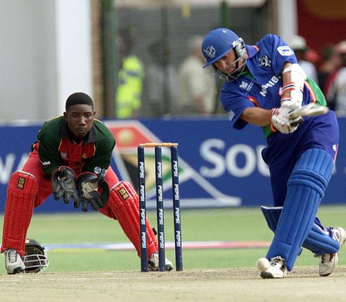 Namibian batsman Daniel Keulder drives a delivery watched by Zimbabwe ...