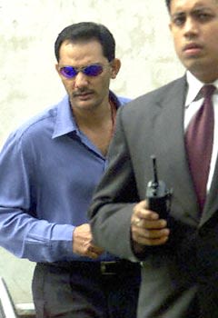 Azhar being escorted by a security officer after the hearing with BCCI ...